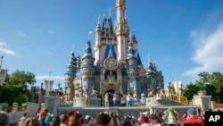 FILE - Performers entertain visitors at Walt Disney World Resort in Lake Buena Vista, Florida, April 18, 2022. Disney has filed a lawsuit against the state's governor, claiming he and his administration violated the company's First Amendment rights.