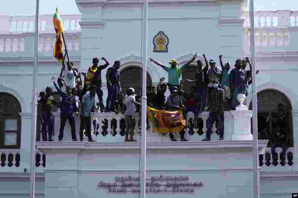 Protesters stand on top of Sri Lankan Prime Minister Ranil Wickremesinghe 's office, demanding he resign after President Gotabaya Rajapaksa fled the country amid economic crisis in Colombo, July 13, 2022.