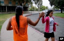 Native American students high fiving as they pass each other at the University of California, Riverside, June 26, 2014.