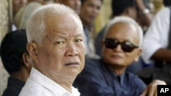 Former Khmer Rouge leaders Khieu Samphan, left, and Nuon Chea, right, look on during the funeral for Khieu Ponnary, the first wife of Khmer Rouge leader Pol Pot, in 2003. 