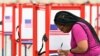 A voter fills out her ballot during the Kentucky Primary at the Kentucky Exposition Center in Louisville, Ky., June 23, 2020. 