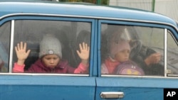 Djeca gledaju kroz prozor automobila dok zajedno sa drugom djecom iz regiona Harkova stižu u privremeni smještaj u prihvatnom kampu u Belgorodu, u Rusiji, 14. septembra 2022. 