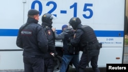 FILE - Russian law enforcement officers detain a person during a rally, after opposition activists called for street protests against the mobilization of reservists ordered by President Vladimir Putin, in Moscow, Sept. 24, 2022.