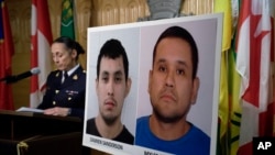Assistant Commissioner Rhonda Blackmore speaks next to images of Damien Sanderson and Myles Sanderson during a press conference at the Royal Canadian Mounted Police "F" Division headquarters in Regina, Saskatchewan, on Sept. 4, 2022. 