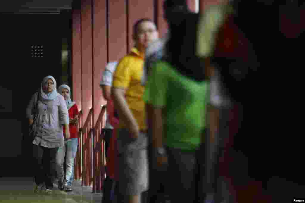 Voters arrive outside a polling station during the general elections in Permatang Pauh, Malaysia, May 5, 2013.