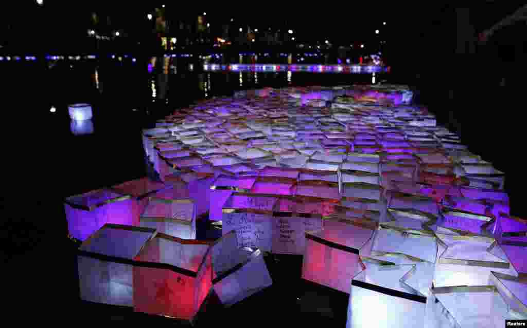 People release floats lit with candles on the Canal Saint-Martin, in Paris, France, after ceremonies held for the victims of last year's Paris attacks which targeted the Bataclan concert hall as well as a series of bars and killed 130 people.