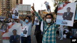 Para pendukung calon presiden Iran, Abdolnasser Hemmati, menunjukkan poster dengan foto-fotonya di Teheran, Iran, Selasa, 15 Juni 2021. 