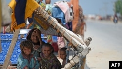 Sejumlah anak-anak mengungsi di bawah tenda buatan di pinggir jalan setelah banjir menerjang pinggiran kota Jacobabad, di provinsi Sindh, Pakistan, pada 6 September 2022. (Foto: AFP/Aamir Qureshi)