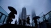 Warga membawa payung di tengah hujan saat Topan Chanthu mendekat, di Shanghai, China 13 September 2021. (REUTERS/Aly Song)