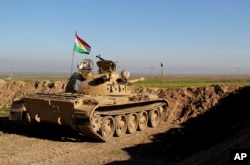 FILE - In this Tuesday, Jan. 20, 2015 file photo released by the Kurdistan Region Security Council, Kurdish peshmerga forces prepare on the front line for battle against Islamic State group positions, in northern Iraq.