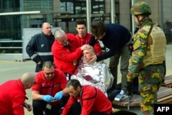 FILE - A victim receives first aid by rescuers, on March 22, 2016 near Maalbeek metro station in Brussels, after a blast at this station near the EU institutions caused deaths and injuries.