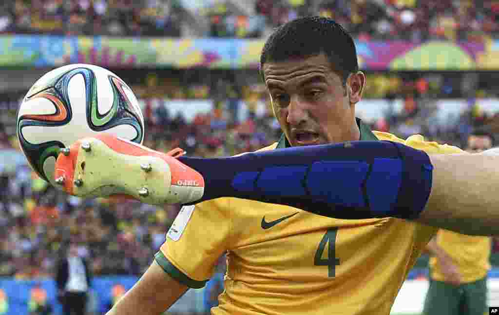 Australia's Tim Cahill, left, watches as Netherlands' Ron Vlaar clears the ball during the group B World Cup soccer match between Australia and the Netherlands at the Estadio Beira-Rio in Porto Alegre, Brazil.