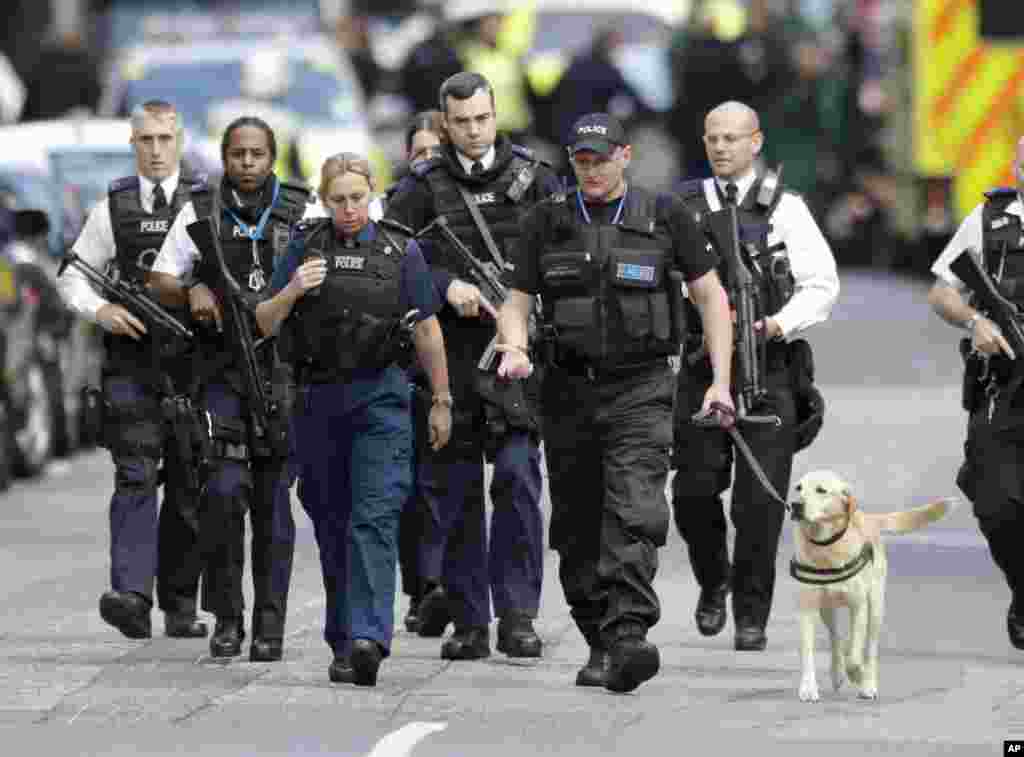 Un grupo de policías británicos caminan con un perro policía en la zona acordonada del área del Puente de Londres donde el sábado por la noche un ataque dejó varios muertos y decenas de heridos. Junio 4 2017. 
