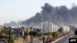 Une fumée noire se répand dans le ciel après l'incendie d'un dépôt pétrolier lors d'affrontements entre des milices rivales près de l'aéroport international de Tripoli, à la périphérie de la capitale, le 13 août 2014.