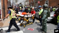 Rescue personnel help injured people after a car ran into a large group of protesters after an white nationalist rally in Charlottesville, Va., Aug. 12, 2017. 