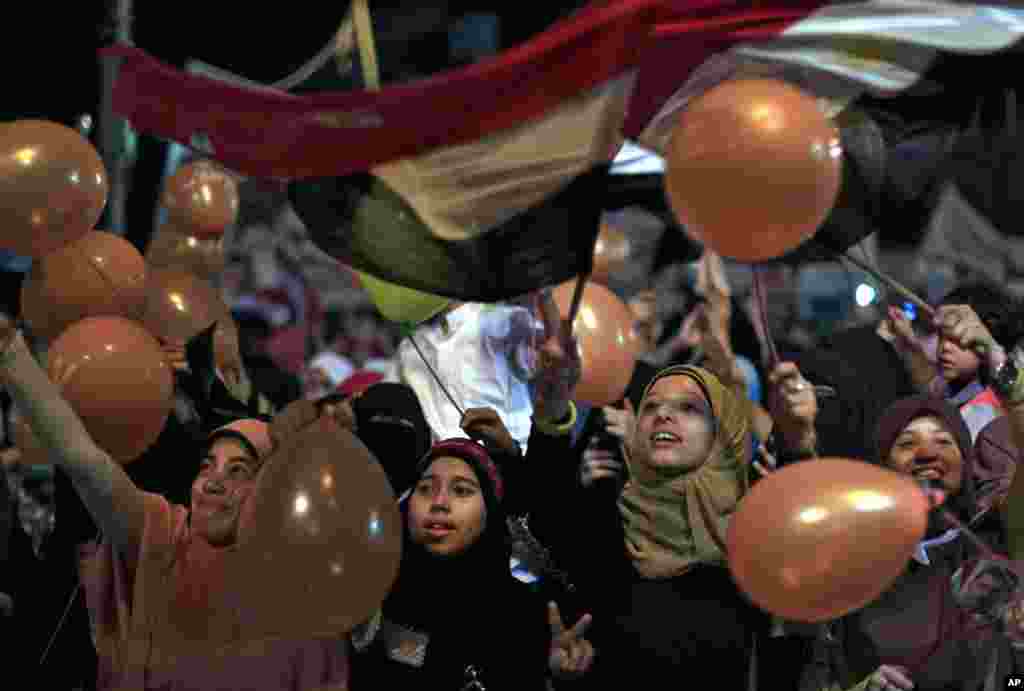 Supporters of Egypt's ousted President Mohamed Morsi hold balloons and national flags as they celebrate the first day of the Eid al-Fitr feast, Cairo, August 8, 2013.