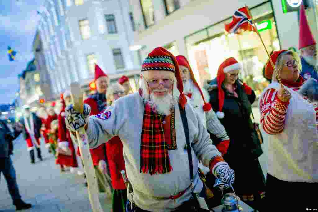 A procession of people dressed as Santa Claus walk down the main street of Oslo, Norway. The people were headed to the Norwegian Parliament building to promote the upcoming "Santa’s Winter Games".