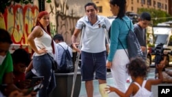 Para migran berdiri di luar markas Yayasan Amal Katholik di kota New York (foto: dok). Walikota New York City berencana mendirikan tempat penampungan sementara bagi ribuan migran yang diangkut dengan bus dari perbatasan selatan AS. 