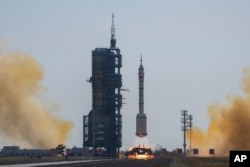 A Long March rocket carrying a crew of Chinese astronauts in a Shenzhou-17 spaceship lifts off at the Jiuquan Satellite Launch Center in northwestern China on October 26, 2023. (AP Photo/Andy Wong)