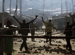 FILE - Protesters demonstrate with sticks and hammers during post-election disturbances in the Mathare slum of Nairobi, Dec. 30, 2007.