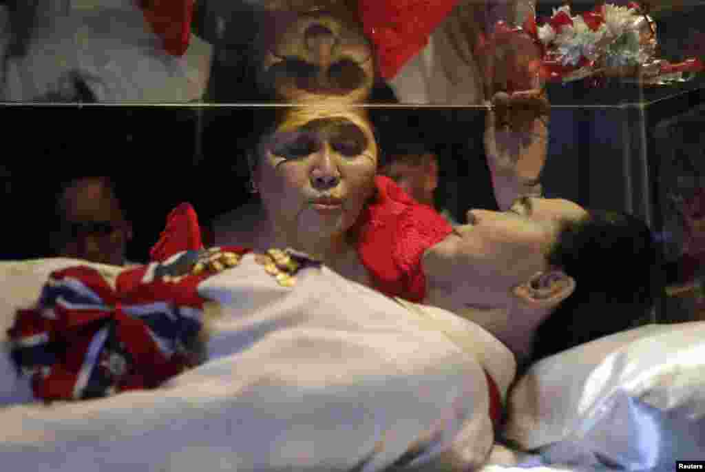 Former First Lady Imelda Marcos kisses the glass coffin of her husband, the late President Ferdinand Marcos, who remains unburied since his death in 1989, during her 85th birthday celebration in Ferdinand Marcos' hometown of Batac, Ilocos Norte province, in northern Philippines.