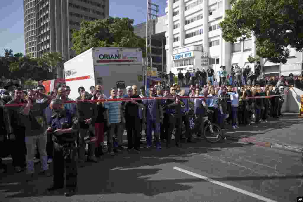 Israelis look at a blown up bus at the site of a bombing in Tel Aviv, Israel, November 21, 2012.