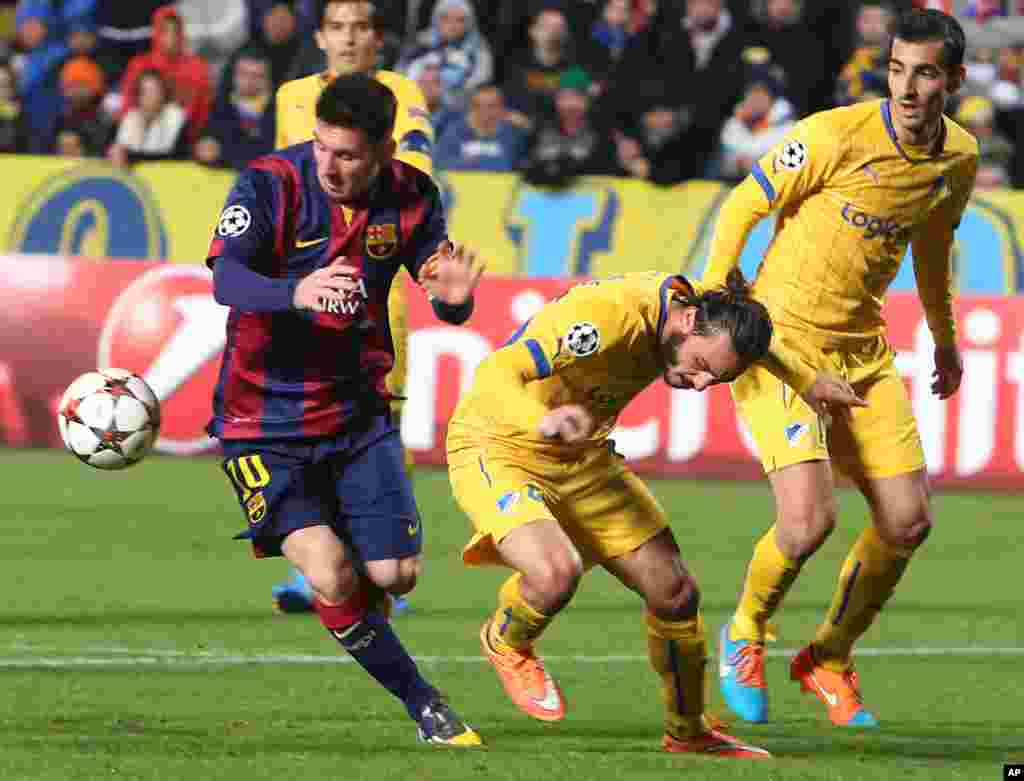 Stathis Aloneftis de l'APOEL, au centre, et Marios Antoniades, à droite, en duel pour la balle avec Lionel Messi de Barcelone, à gauche, lors du match de football de la Ligue des Champions Groupe F entre Apoel et Barcelone, au stade GSP, à Nicosie, Chypre, le mardi 25 novembre , 2014.