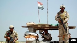 Iraqi government troops at a checkpoint in the Jurf al-Sakher area, some 50 kilometers south of Baghdad, to protect the area from further Islamic State (IS) group advancement, on May 24, 2015. (AFP PHOTO / HAIDAR HAMDANI)