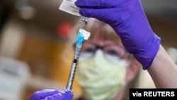 Seorang perawat mempersiapkan vaksin Covid-19 di UW Health, Madison, Wisconsin, Amerika Serikat, 14 Desember 2020. 