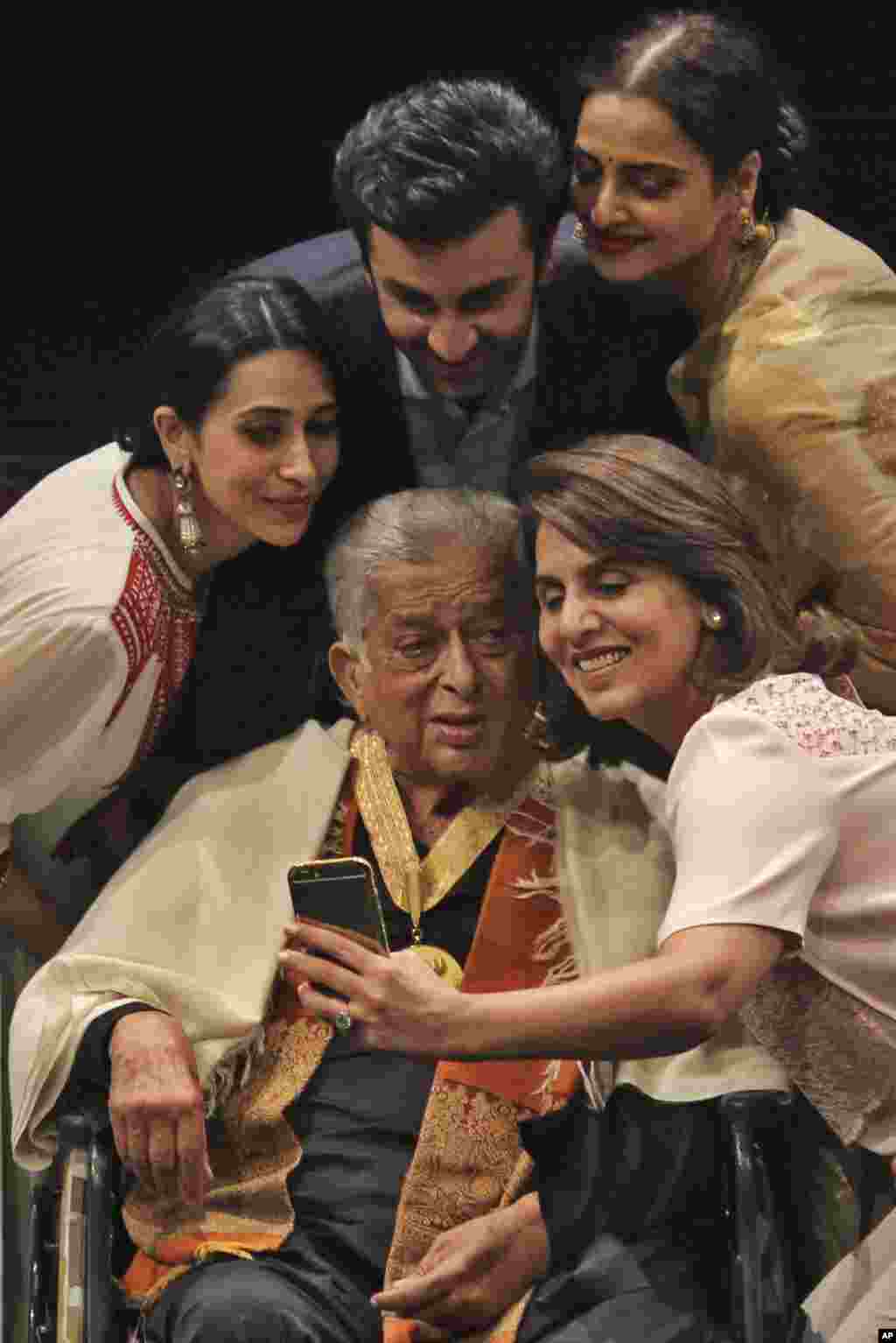Shahararrun jarumai na Bollywood, daga hagu, Karisma Kapoor, Ranbir Kapoor, Rekha da Neetu Singh su na daukar hoto da shahararren dan fim Shashi Kapoor, wanda ke zaune a kujera, a wurin bukin da aka ba shi lambar yabo mafi girma a harkar fim ta Indiya, "Dadasaheb Phalke Award" ranar 10 Mayu 2015 a Mumbai.(AP Photo)