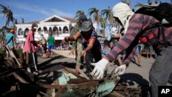 Typhoon survivors and volunteers begin a massive clean up in typhoon-ravaged Tacloban city, Leyte province in central Philippines, Nov. 25, 2013. 