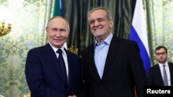 Russian President Vladimir Putin and Iranian President Masoud Pezeshkian shake hands as they meet in Moscow, Jan. 17, 2025. 