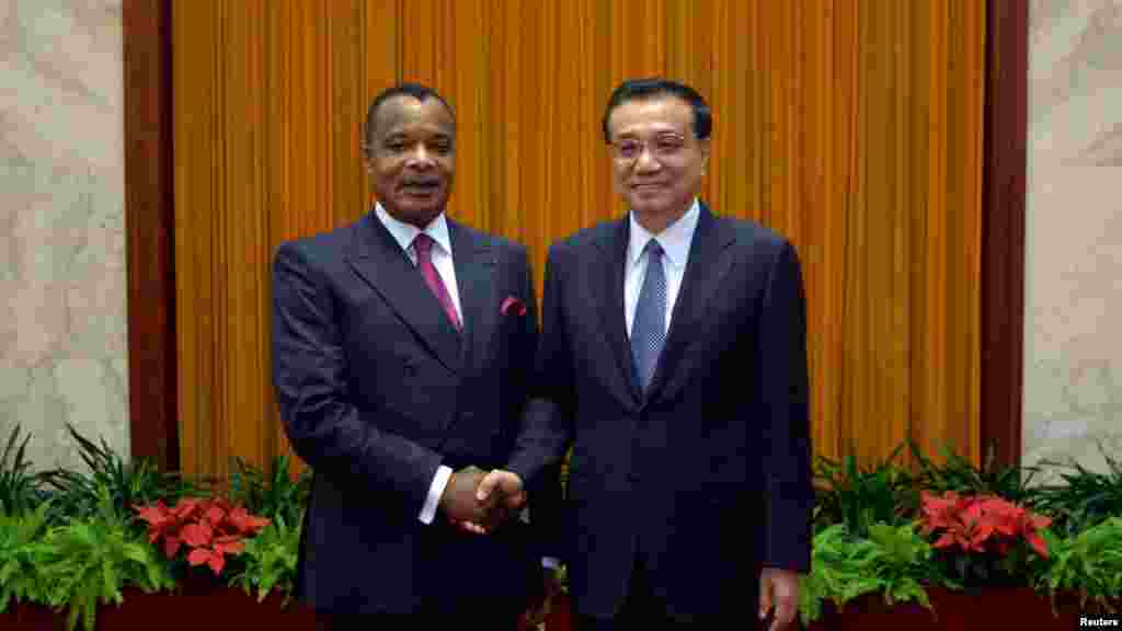 Poignée de main entre le président Denis Sassou Nguesso de la République du Congo et le Premier ministre chinois Li Keqiang au Grand Palais du Peuple à Beijing, Chine, 13 juin 2014. 