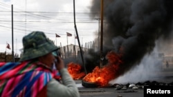 Seorang pria berdiri dekat sebuah unjuk rasa di Senkata, El Alto, Bolivia, 19 November 2019. 