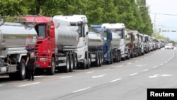 Anggota serikat Solidaritas Pengemudi Truk Kargo berdiri di samping truk saat mogok kerja di Yeosu, Korea Selatan, 9 Juni 2022. (Foto: via Reuters)
