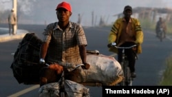 A man on a bicycle carries charcoal to sell at Mafambisse, about 60km outside of Beira, Mozambique, Tuesday, March 26, 2019.