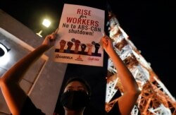 An activist holds a slogan outside the headquarters of broadcast network ABS-CBN corp. on Tuesday, May 5, 2020 in Quezon city, Metro Manila, Philippines.