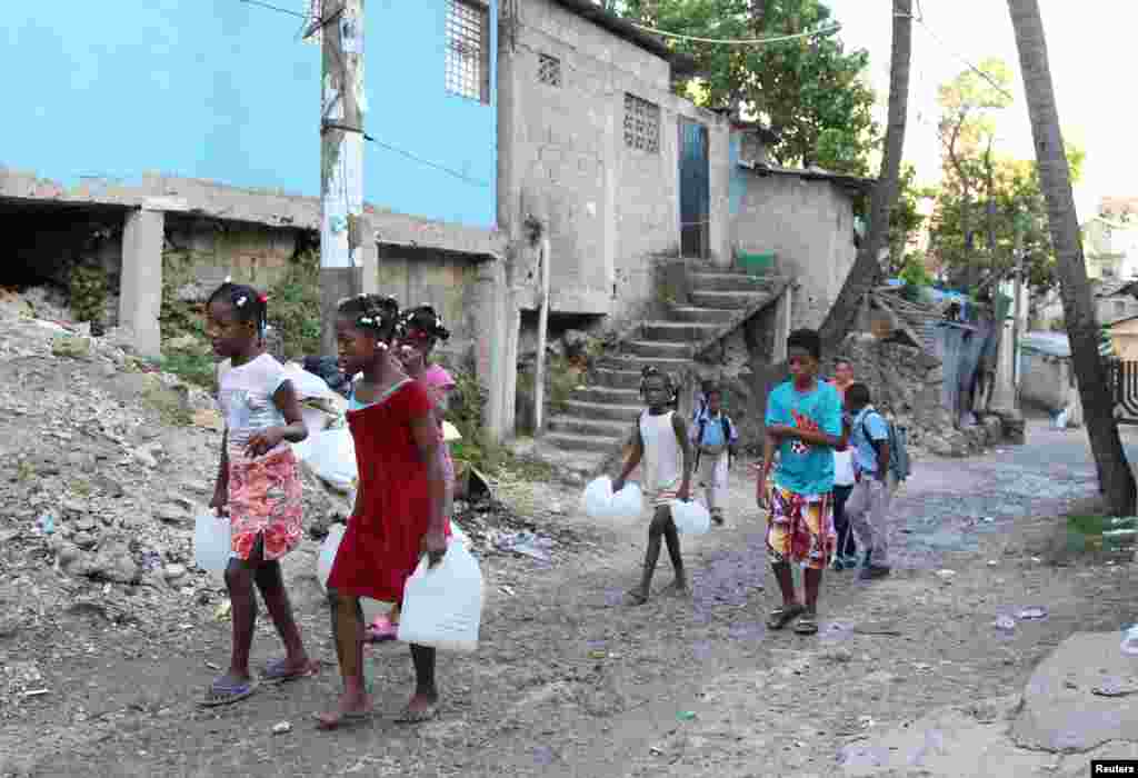 Children in a low-income neighborhood carry containers for water as Hurricane Irma slams across islands in the northern Caribbean in Santo Domingo, Dominican Republic, Sept. 6, 2017.