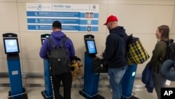 International travelers stop and use the portal to get their initial processing and instructions on their next procedure, in the port of entry at Washington Dulles International Airport in Chantilly, Va. Monday, April 1, 2024. (AP Photo/Manuel Balce Ceneta)