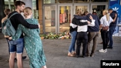 People embrace at the closed Field's Shopping Center after yesterday's shooting where three were killed, in Copenhagen, Denmark, July 4, 2022. (Ritzau Scanpix/Mads Claus Rasmussen via Reuters)