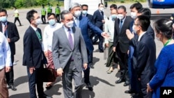 Menteri Luar Negeri China Wang Yi (tengah) disambut oleh perwakilan Kementerian Luar Negeri Myanmar dan Kedutaan Besar China di Myanmar ketika tiba di Bandara Nyaung Oo di Bagan, Myanmar, pada 2 Juli 2022. (Foto: Myanmar Ministry of Information via AP)