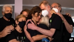 Para kerabat dari jurnalis Dom Phillips memeluk Alessandra Sampaio (tengah), istri dari Phillips, dalam konferensi pers pada acara pemakaman Phillips di Niteroi, Brazil, pada 26 Juni 2022. (Foto: AP/Silvia Izquierdo)