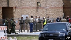 Para petugas keamanan berkumpul di luar gedung sekolah dasar Robb di Uvalde, Texas setelah terjadi penembakan (dok: AP)