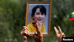 A person holds a picture of leader Aung San Suu Kyi as Myanmar citizens protest against the military coup in front of the UN office in Bangkok, Thailand Feb. 22, 2021. REUTERS/Soe Zeya Tun/File Photo