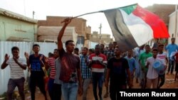 Des manifestants soudanais scandent des slogans et agitent leur drapeau national alors qu'ils manifestent contre le conseil militaire au pouvoir, à Khartoum, le 29 juin 2019/Reuters