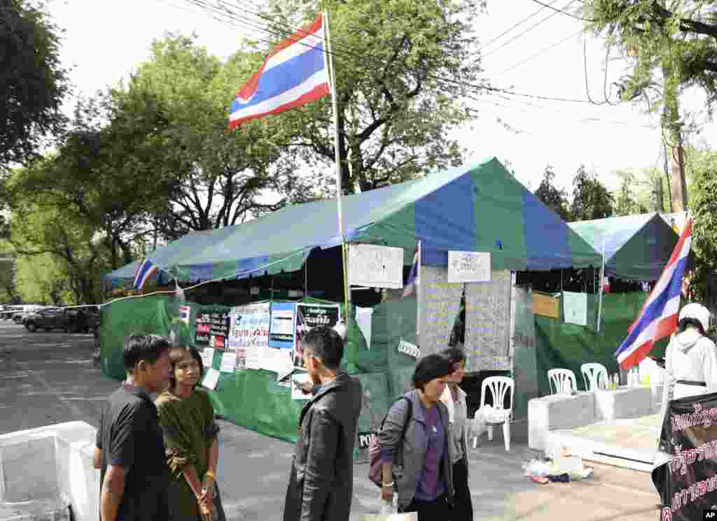 Thai anti-government protesters chat outside a makeshift camp where their colleagues were shot outside the prime minister's office of Government House in Bangkok, Thailand.
