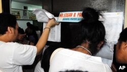 Voters check their papers at a polling station in the Philippine election