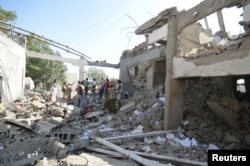 People gather at a prison struck by Arab coalition warplanes in al-Zaydiyah district of the Red Sea port city of Hodeidah, Yemen, Oct. 30, 2016.