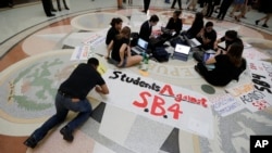 FILE - Students gather in the Texas Capitol to oppose SB4, an anti-sanctuary-cities bill that seeks to jail sheriffs and other officials who refuse to help enforce federal immigration law, in Austin, Texas, April 26, 2017.