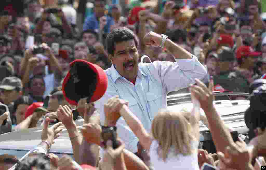 Pejabat Presiden Nicolas Maduro di depan para pendukungnya usai memberikan suara dalam pemilihan presiden di Caracas, Venezuela (14/4). Maduro, mantan menteri luar negeri dan wakil presiden untuk Presiden Hugo Chavez, menghadapi kandidat oposisi Henrique Capriles.